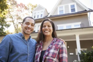 Common plumbing emergencies - Portrait Of Smiling Couple Standing In Front Of Their Home
